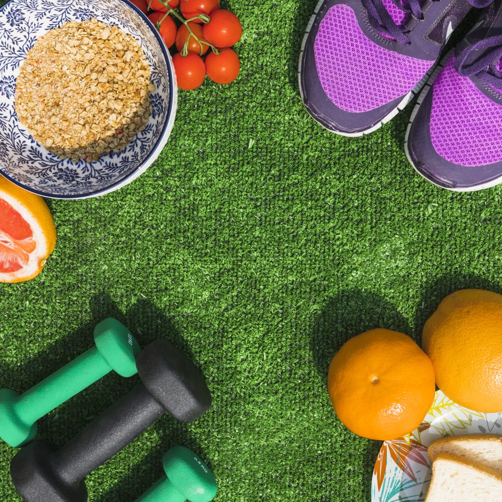 healthy-food-with-pair-of-sport-shoes-and-dumbbells-on-turf